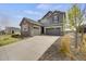 Attractive two-story home featuring a three-car garage and a blend of stone and gray siding at 6802 S Uriah St, Aurora, CO 80016