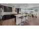 Modern kitchen with dark cabinets, a white countertop island with seating, and stainless steel appliances, perfect for cooking at 6802 S Uriah St, Aurora, CO 80016