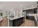 Spacious kitchen featuring a large island, stainless steel appliances, dark wood cabinets, and an open layout into living spaces at 6802 S Uriah St, Aurora, CO 80016