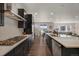 Elegant kitchen with dark cabinets, stainless steel appliances, and open access to the dining and living areas for seamless entertaining at 6802 S Uriah St, Aurora, CO 80016