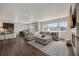 Open-concept living room with a large sectional, and barstool seating at kitchen island at 6802 S Uriah St, Aurora, CO 80016