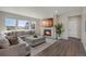 Spacious living room with a cozy fireplace, large sectional, and bright natural light at 6802 S Uriah St, Aurora, CO 80016
