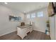 Home office with a large desk, ample natural light from three windows, and neutral decor, creating a productive workspace at 6802 S Uriah St, Aurora, CO 80016