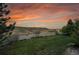 Beautiful backyard view featuring a golden sky, green grass, white fence and mountain view at 3790 Aspen Hollow Ct, Castle Rock, CO 80104