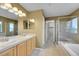 Bright bathroom featuring double sinks, a glass shower, and a separate soaking tub for a luxurious experience at 3790 Aspen Hollow Ct, Castle Rock, CO 80104