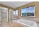Luxurious bathroom with a glass shower, soaking tub, and scenic window view, offering relaxation and style at 3790 Aspen Hollow Ct, Castle Rock, CO 80104