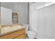 Bright bathroom featuring a single sink vanity, toilet, and shower with a white curtain for added privacy at 3342 Springmeadow Cir, Castle Rock, CO 80109