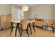 Neutral dining area featuring wood furniture and flooring, with large window and modern light fixture at 3342 Springmeadow Cir, Castle Rock, CO 80109