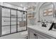 This is a bathroom with a black framed shower, a stylish floating vanity, and a sleek color palette at 10042 Hudson St, Thornton, CO 80229
