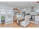 Bright dining area with table, chairs, modern lighting, adjacent to a kitchen with white cabinets at 10042 Hudson St, Thornton, CO 80229