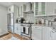 Modern kitchen with stainless steel appliances, white cabinets, and granite countertops at 10042 Hudson St, Thornton, CO 80229