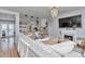 Open-concept living room with fireplace, TV, comfortable seating flowing into kitchen and dining area at 10042 Hudson St, Thornton, CO 80229