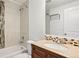 Bathroom featuring a modern vanity, stylish tiling, and a shower over tub with glass door at 4190 W Alameda Ave, Denver, CO 80219