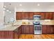 Well-equipped kitchen featuring stainless steel appliances, granite countertops and wooden cabinets at 4190 W Alameda Ave, Denver, CO 80219