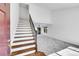 Bright entryway with wooden stairs, iron balusters, and neutral carpeting, leading to the spacious living area at 10057 Cedaridge Way, Highlands Ranch, CO 80129