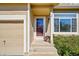 Covered front entry with sidelight and storm door, adjacent to a two car garage at 10057 Cedaridge Way, Highlands Ranch, CO 80129