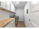 Laundry room with front load washer/dryer, wood counter top and white cabinets at 8767 Chase Dr # 195, Arvada, CO 80003