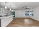Open-concept kitchen and living space with island seating, hardwood floors, and abundant natural light at 8767 Chase Dr # 195, Arvada, CO 80003