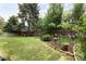 Lush backyard featuring a large lawn area, mature trees, and beautiful landscaping at 10572 E Orchard Pl, Englewood, CO 80111