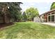 Expansive backyard featuring a large lawn area, mature trees, a patio, and beautiful landscaping at 10572 E Orchard Pl, Englewood, CO 80111