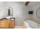 An elegant bathroom boasts a jetted tub, vanity with vessel sink, and modern fixtures at 10572 E Orchard Pl, Englewood, CO 80111