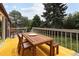 Exterior wooden deck with seating overlooks tree-filled backyard at 10572 E Orchard Pl, Englewood, CO 80111