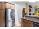 Well-lit kitchen featuring stainless steel appliances, granite countertops, and wood cabinetry at 10572 E Orchard Pl, Englewood, CO 80111