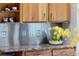 Close up of granite counters with stainless steel backsplash and natural wood cabinets at 10572 E Orchard Pl, Englewood, CO 80111
