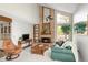 Living room with high vaulted ceilings, brick fireplace, and large picture windows at 10572 E Orchard Pl, Englewood, CO 80111