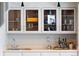 Wet bar featuring glass-front cabinets, neutral countertops, stainless sink and stylish fixtures at 10572 E Orchard Pl, Englewood, CO 80111