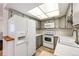 Galley kitchen with white appliances and gray cabinets at 14393 E Marina Dr, Aurora, CO 80014