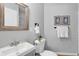 Cozy bathroom featuring framed art, a white toilet, and a sink with a wood-trimmed mirror at 2735 S Dahlia St, Denver, CO 80222