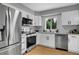 Bright kitchen featuring stainless steel appliances, white cabinets, and stone countertops at 2735 S Dahlia St, Denver, CO 80222