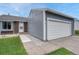 Exterior view of a two car garage with a gray exterior, white garage door and concrete walkway at 19140 E Milan Cir, Aurora, CO 80013