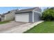 Exterior of a two car garage showcasing the gray exterior, white garage door and long concrete driveway at 19140 E Milan Cir, Aurora, CO 80013