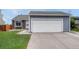 Exterior view of a two car garage with a gray exterior, white garage door and concrete driveway at 19140 E Milan Cir, Aurora, CO 80013