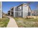 View of building exterior with gray siding, chimney, and bench at 3482 S Eagle St # 102, Aurora, CO 80014