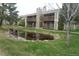 Apartment complex with lush lawn and pond reflecting property at 3482 S Eagle St # 102, Aurora, CO 80014