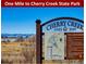 Sign indicates Cherry Creek State Park is one mile away, advertising nearby recreation at 3482 S Eagle St # 102, Aurora, CO 80014