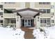 Facade of building entrance featuring contemporary architecture in a snow-covered landscape at 595 S Alton Way # 1C, Denver, CO 80247
