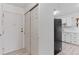 Bright entryway leading to a modern kitchen with stainless steel appliances and white cabinetry at 595 S Alton Way # 1C, Denver, CO 80247
