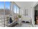 Enclosed sun room featuring cozy seating, outdoor views, and access to the indoors through a glass door at 595 S Alton Way # 1C, Denver, CO 80247