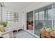 A bright patio with white furniture, an area rug and sliding glass door into the living room at 595 S Alton Way # 1C, Denver, CO 80247