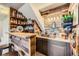 Basement bar with wood accents, brick, shelves, sink, and custom lighting at 330 N Wagonwheel Trl, Castle Rock, CO 80104