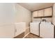 Functional laundry room with washer, dryer, cabinets, and modern wood-look floors at 330 N Wagonwheel Trl, Castle Rock, CO 80104