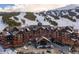 An elegant multi-story resort with a porte-cochere and ample parking, set against a backdrop of ski slopes at 1521 Ski Hill Rd # 8318, Breckenridge, CO 80424