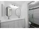 Bright bathroom featuring a double sink vanity, oval mirrors, and glass shower door at 8422 S Upham Way # G60, Littleton, CO 80128