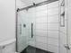 Modern shower with glass door and large white tiles and black tiled flooring at 8422 S Upham Way # G60, Littleton, CO 80128