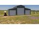 Large gray barn with three doors sits on a grassy field at 11809 Pass Me By Rd, Strasburg, CO 80136