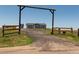 Gated driveway leads to a single-story home under a clear sky at 11809 Pass Me By Rd, Strasburg, CO 80136